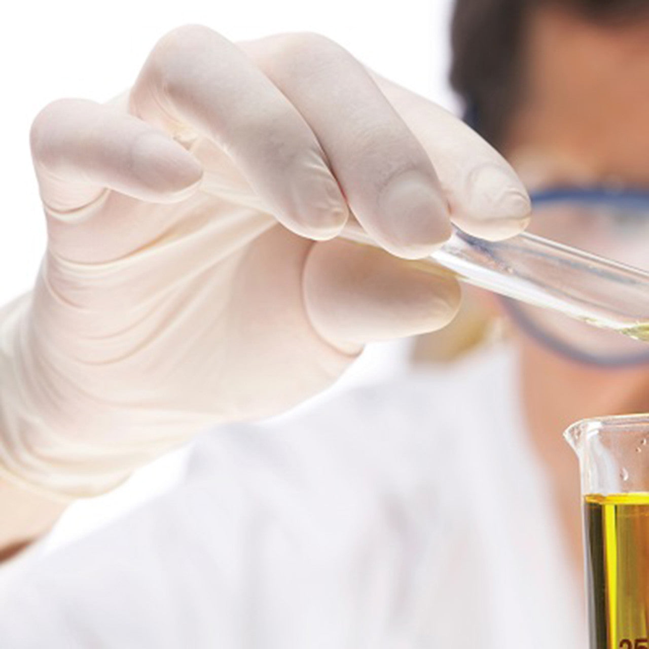 Person wearing gloves holding a test tube with a clear liquid, with a blurred background
