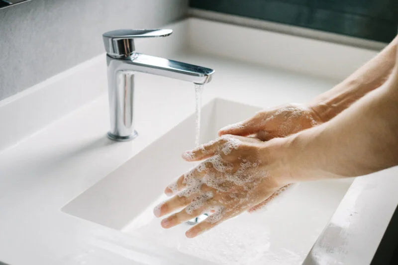 Healthcare professional washing hands using Dermalux Everyday Hand Soap to support frequent hand washing and help maintain skin integrity.