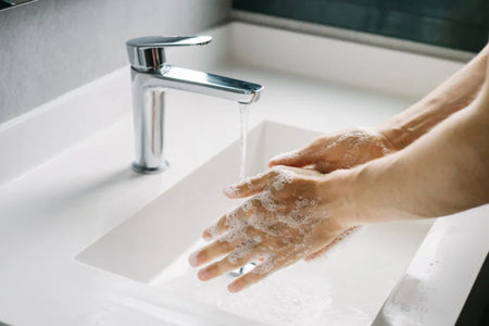 Healthcare professional washing hands using Dermalux Everyday Hand Soap to support frequent hand washing and help maintain skin integrity.
