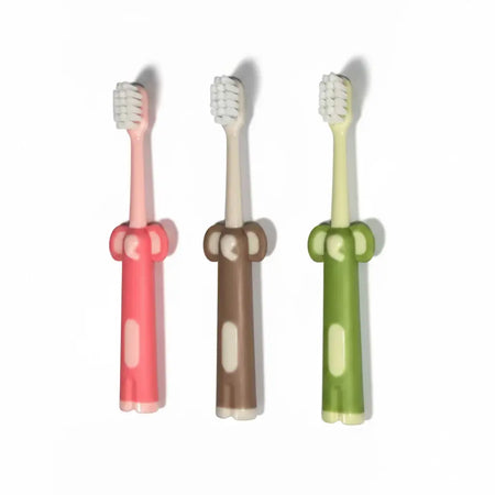Assorted colours Kids Ultra Soft Toothbrushes with elephant-shaped handles arranged vertically on a white background, featuring pink, brownish beige and green handles with white bristle heads.